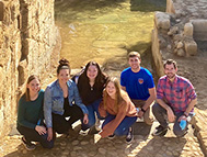 Students and a professor pose in front of a Mexican landmark